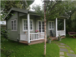 Traditional garden log cabin, cricket pavilion style, with veranda and balustrades.  Custom designs available. Gallery Thumbnail