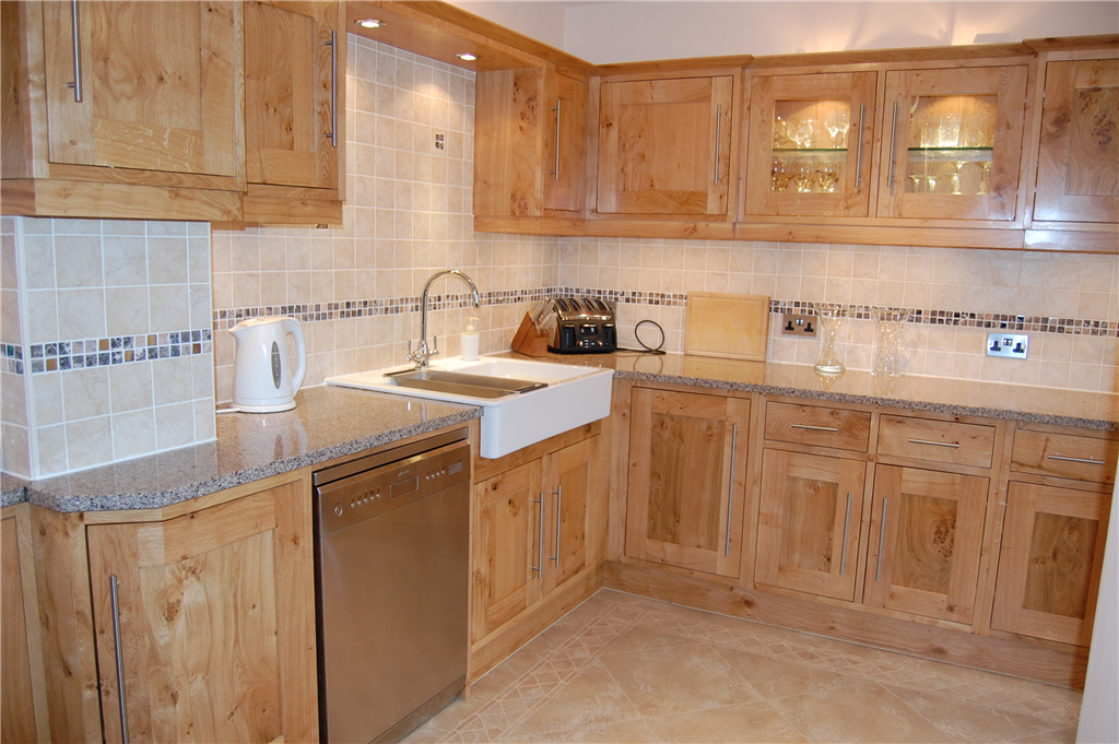 Bespoke Pippy Oak Shaker style kitchen, glass display unit with glass shelves, Quartz worktops, stainless steel appliances and Belfast sink. Gallery Image