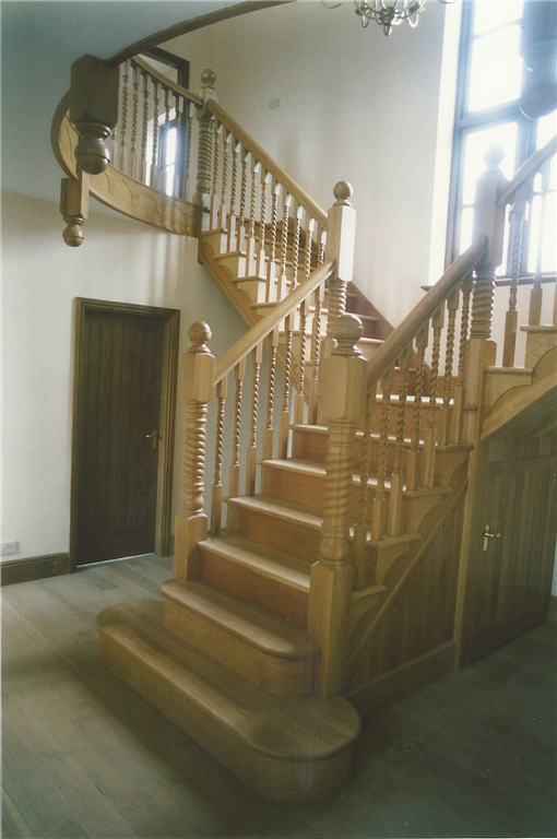 A feature staircase handmade by craftsmen in English Oak, featuring barley sugar twist balusters in the design. Gallery Image