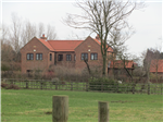 A rural replacement dwelling in handmade brickwork under a pantiled and plain clay tiles pitched roof, adjacent to stables.  Gallery Thumbnail